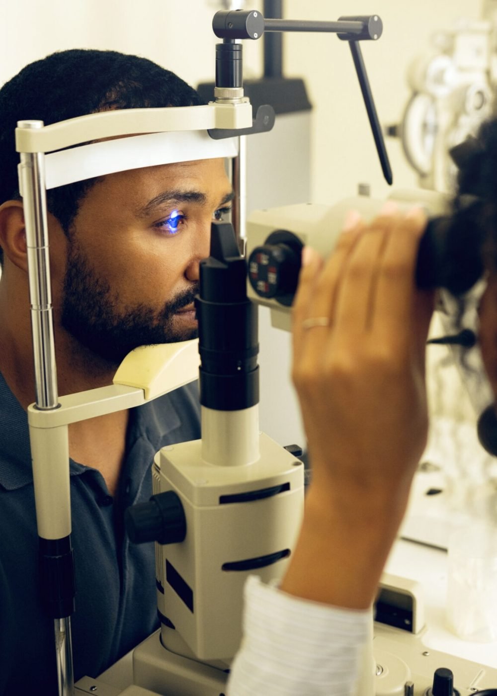 Man, eye exam and optometry for vision, medical and healthcare consultation with glaucoma check. Client and doctor or expert with laser, blue light or machine for scanning eyes and ophthalmology test.