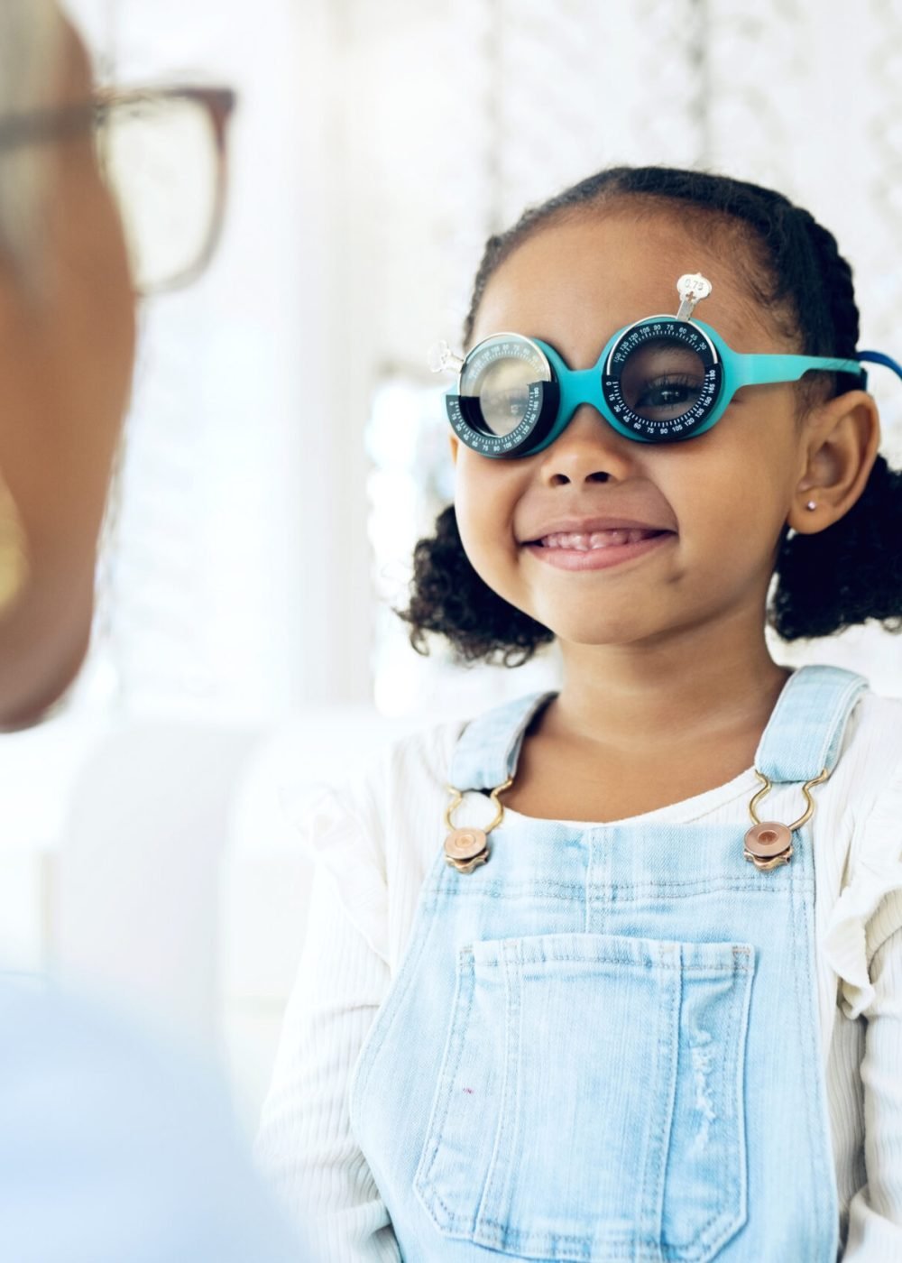 Vision, glasses or eye test with a girl and optician in an eyewear store for prescription frame lenses. Medical, consulting or spectacles with a young child and woman optometrist in an office.